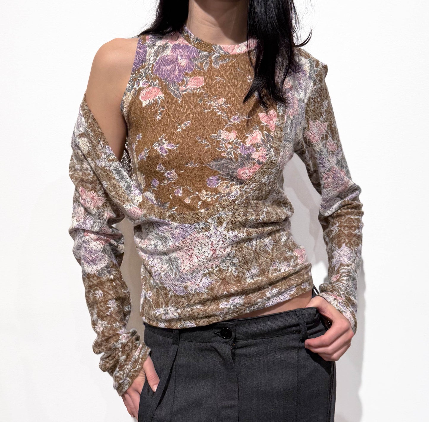 Person wearing a floral long-sleeve top with a plain background